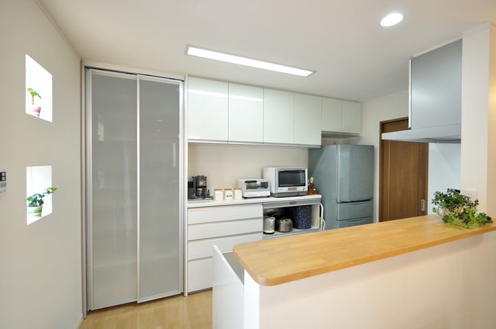 ダイニングから臨むキッチンは、奥様が好きなライトグリーンでスタイリッシュにま...