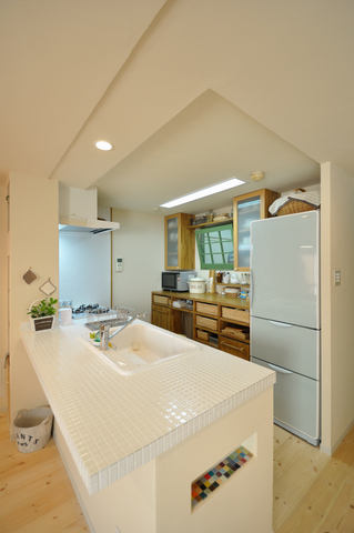 開放的なオープンキッチンは、壁を撤去し、天板は優しげな白いタイル仕上げ。まだ...