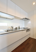 システムキッチンは部屋の色調に合わせてホワイトのラクエラ（クリナップ）を設置...