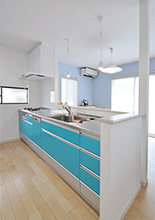 鮮やかなスカイブルーのシステムキッチンはクリナップ（クリンレディ）。お料理し...
