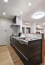 キッチンは、明るい内装のアクセントにブラウンカラーのクリナップ（ラクエラ）を...