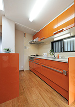 キッチンは「太陽のような温かみのあるものに」と奥様の好きなオレンジ色を採用。...