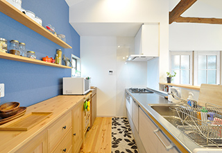 事例No.155のキッチンまわりを参考にした背面収納は、趣きのある梁とのバランスを...