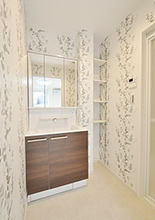 新設した洗面脱衣室は、ボタニカル柄の壁紙にしてナチュラルな印象に。構造柱とお...