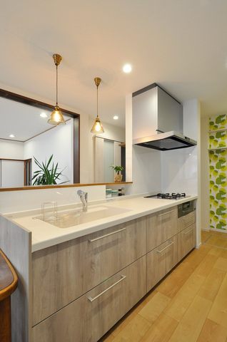 壁付けキッチンから対面式へと変更し、居間にいるご家族と向き合えるレイアウトに...