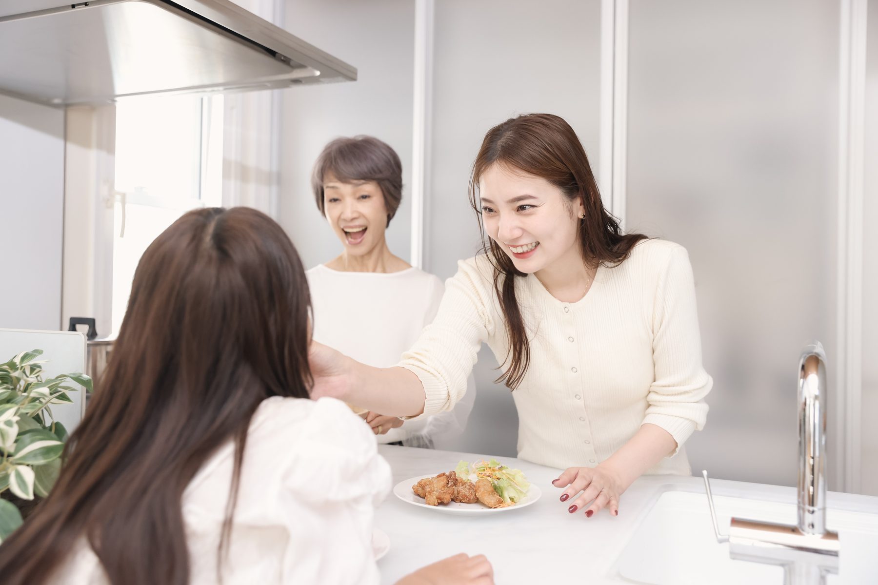 キッチンで三世代いっしょに食事の支度をする様子