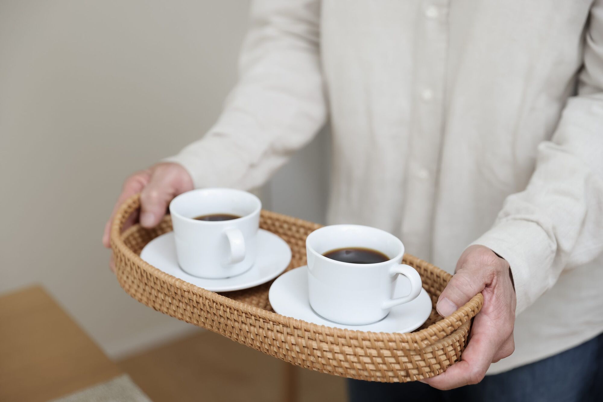 コーヒーカップをのせたトレイを運ぶ手元
